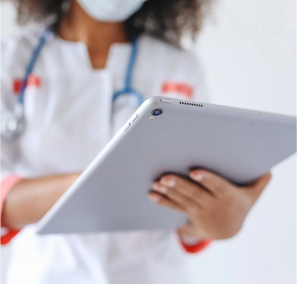 Enfermera trabajando en tablet con mascarilla